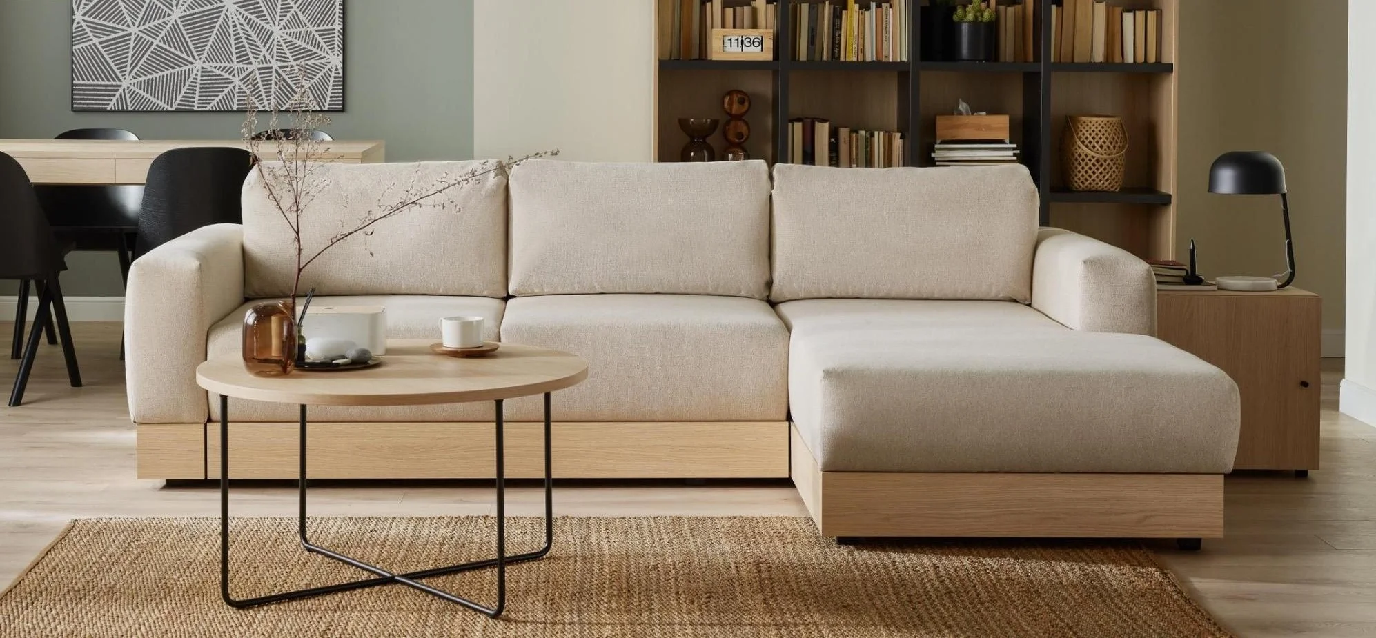 Jasna narożna sofa z drewnianą listwą w przytulnym salonie